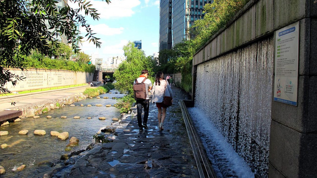 a couple walking down Cheonggyecheon